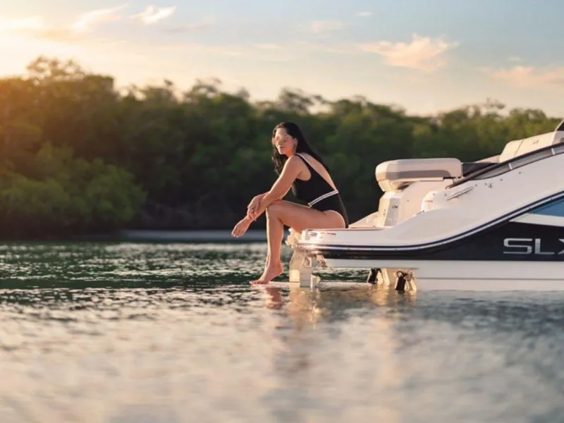 Slide: The Image of Woman relaxing on a 2023 Sea Ray SLX 260 boat at sunset. - 6