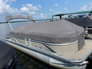 Slide: The Image of 2018 Premier 220 SunSation pontoon boat with cover docked on a lake. - 0