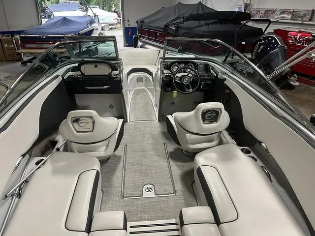Slide: The Image of 2020 Crownline 235 SS boat interior with seating and steering wheel in a showroom. - 4