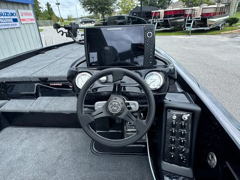 Slide: The Image of Phoenix 920 Elite 2 boat dashboard with steering wheel and electronics, 2025 model. - 10