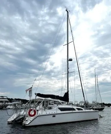 Slide: The Image of 2010 Gemini 105Mc catamaran sailing on a cloudy day in a marina. - 1