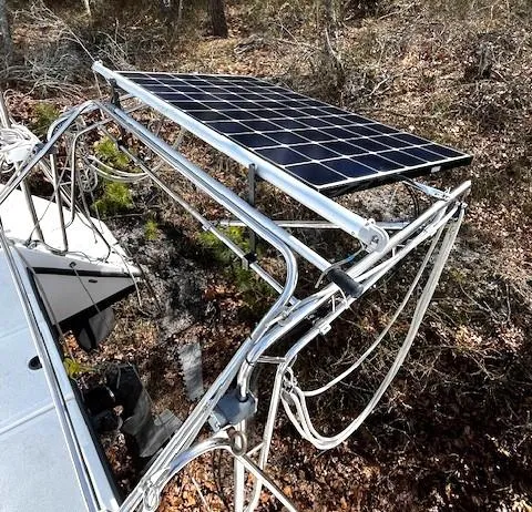 Slide: The Image of Solar panel mounted on a 2010 Gemini 105Mc sailboat, surrounded by forest terrain. - 10