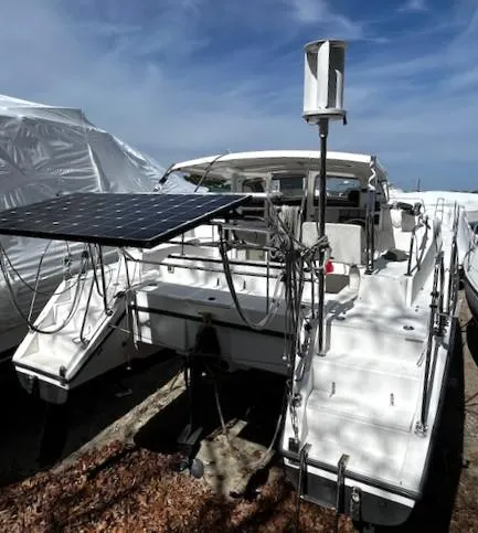 Slide: The Image of 2010 Gemini 105Mc catamaran with solar panel and wind turbine, docked under clear skies. - 11