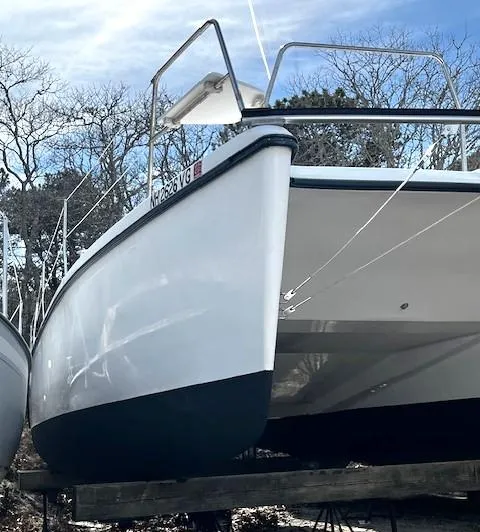 Slide: The Image of 2010 Gemini 105Mc catamaran on a trailer, viewed from the front, with trees in the background. - 19