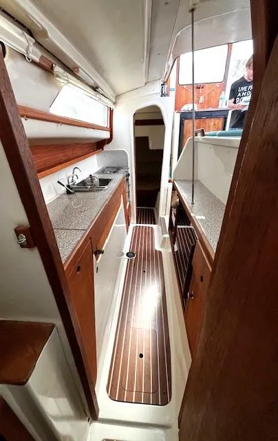 Slide: The Image of Interior of 2010 Gemini 105Mc sailboat with wood accents and compact kitchen area. - 39