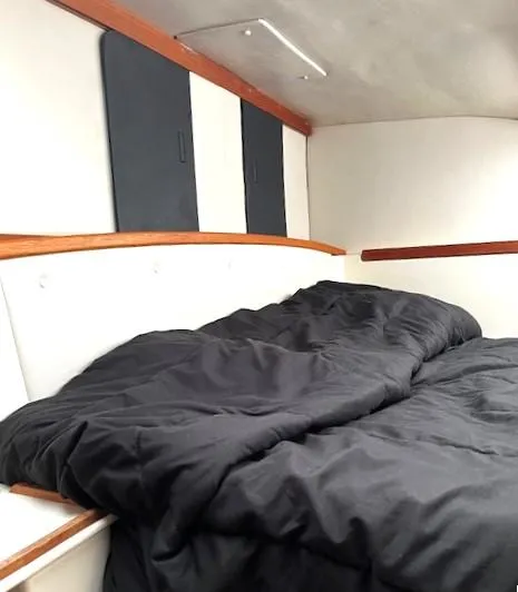 Slide: The Image of Cozy cabin interior of 2010 Gemini 105Mc sailboat with black bedding. - 41