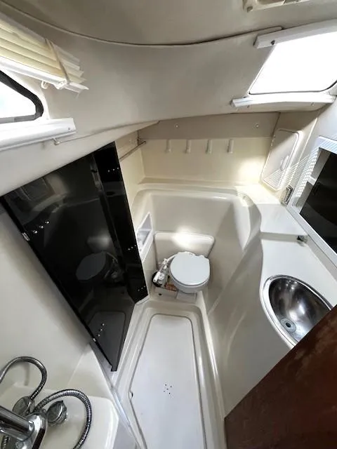 Slide: The Image of 2010 Gemini 105Mc boat interior bathroom with toilet, sink, and shower area. - 43