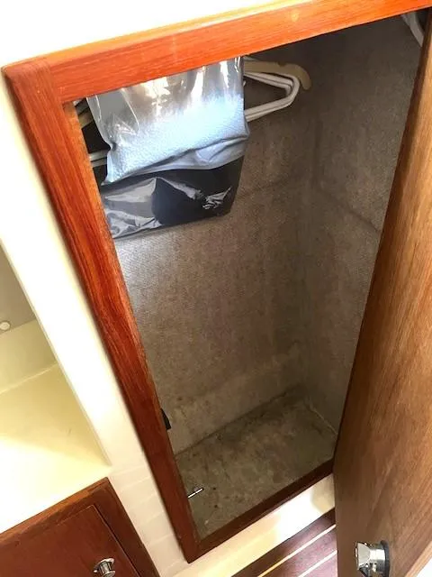 Slide: The Image of Wooden closet interior on a 2010 Gemini 105Mc boat, featuring hangers and storage space. - 46