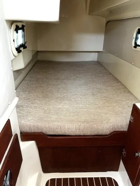 Slide: The Image of Interior cabin of a 2010 Gemini 105Mc boat with a cozy bed and wooden accents. - 49