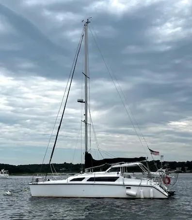 Slide: The Image of 2010 Gemini 105Mc catamaran sailing on a cloudy day, anchored in calm waters. - 7
