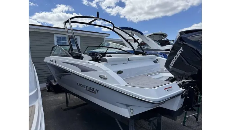 The Image of 2022 Monterey M225 boat with Mercury outboard motor, docked under a partly cloudy sky. - 1