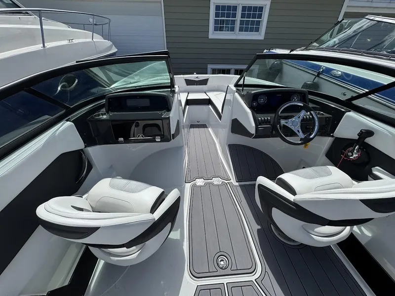 Slide: The Image of 2022 Monterey M225 boat interior with dual captain's chairs and modern dashboard. - 10