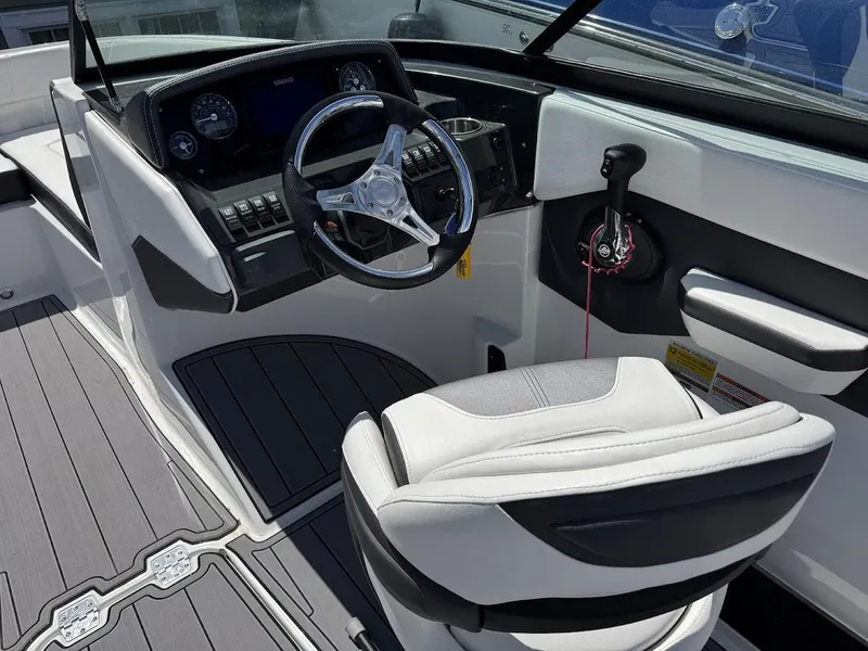 Slide: The Image of 2022 Monterey M225 boat cockpit with steering wheel and captain's chair. - 6