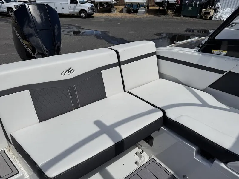 Slide: The Image of 2022 Monterey M225 boat with white and black seating in a marina. - 9