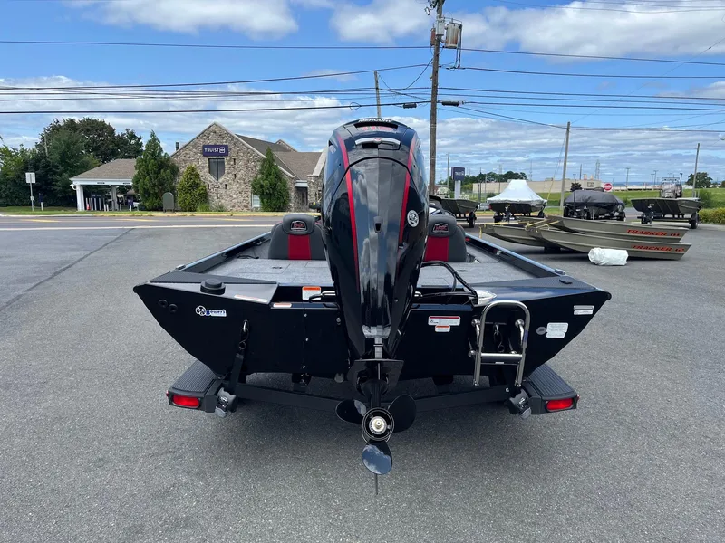 Slide: The Image of 2024 Ranger RT188 boat with outboard motor, parked outdoors on a sunny day. - 2