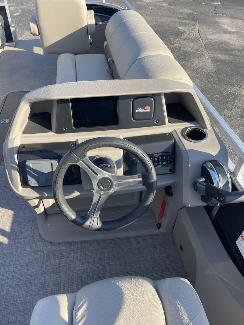 Slide: The Image of 2024 Sun Tracker Sportfish 24 XP3 boat dashboard with steering wheel and controls. - 13