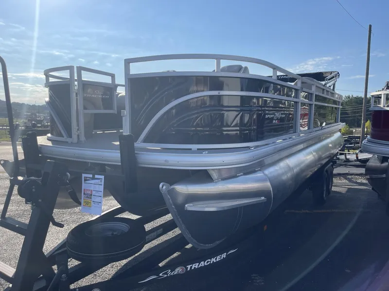 Slide: The Image of 2024 Sun Tracker Sportfish 24 XP3 pontoon boat on display in a parking lot. - 2
