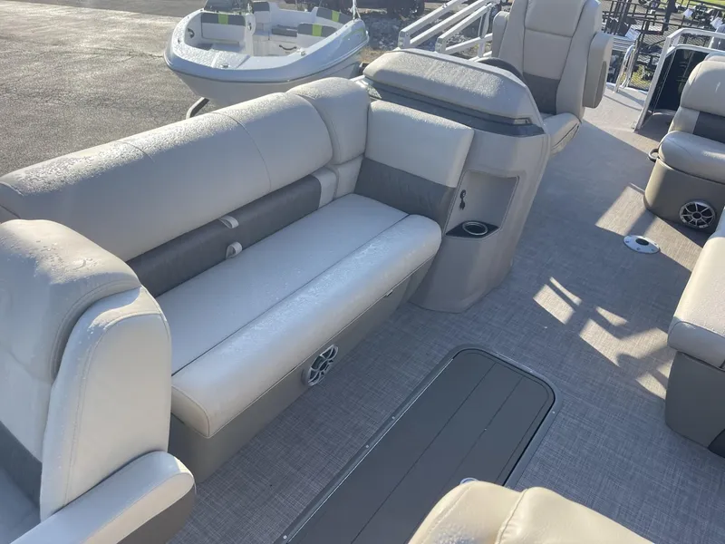 Slide: The Image of 2024 Sun Tracker Sportfish 24 XP3 pontoon boat interior with beige seating and carpeted floor. - 8