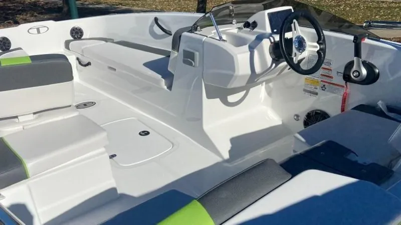 Slide: The Image of 2024 Tahoe T18 boat interior with white and gray seating, steering wheel, and control panel. - 2