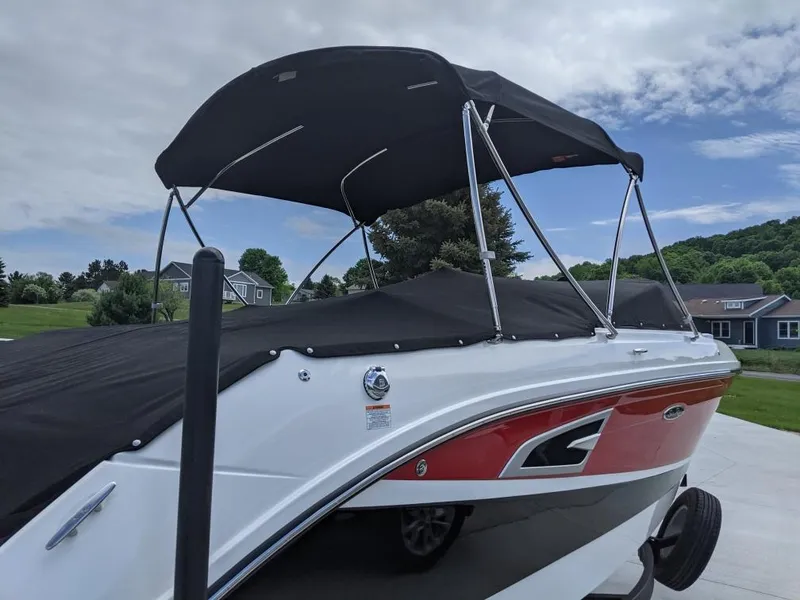 Slide: The Image of 2021 Sea Ray SLX 230 boat with black canopy and red accents. - 1