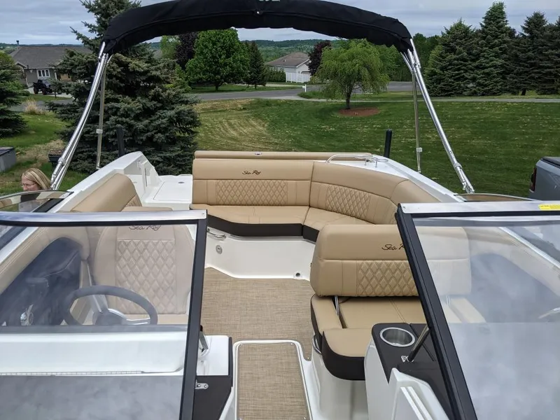 Slide: The Image of 2021 Sea Ray SLX 230 boat with tan leather seating and black canopy. - 2