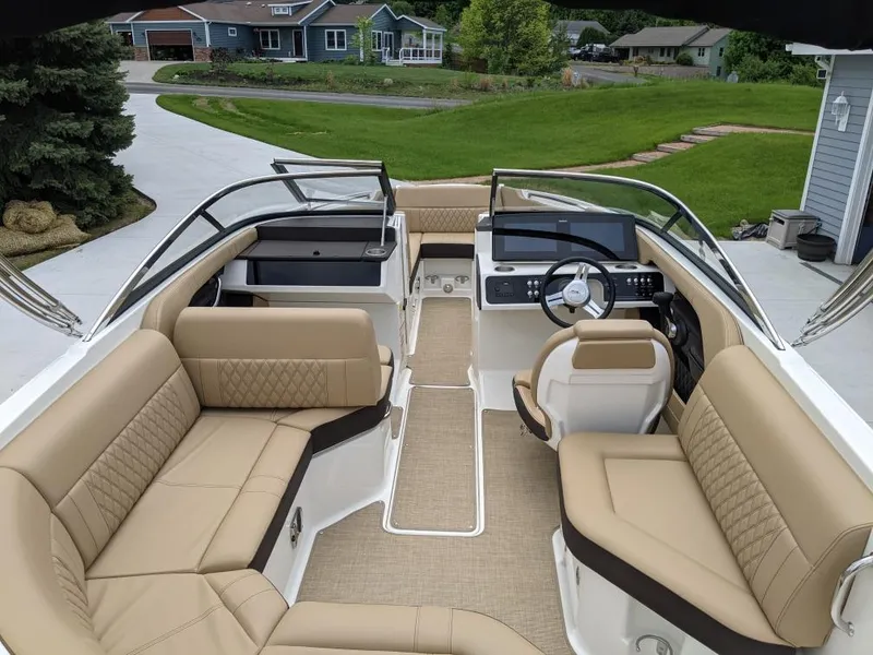 Slide: The Image of 2021 Sea Ray SLX 230 boat interior with beige seating and modern dashboard. - 3