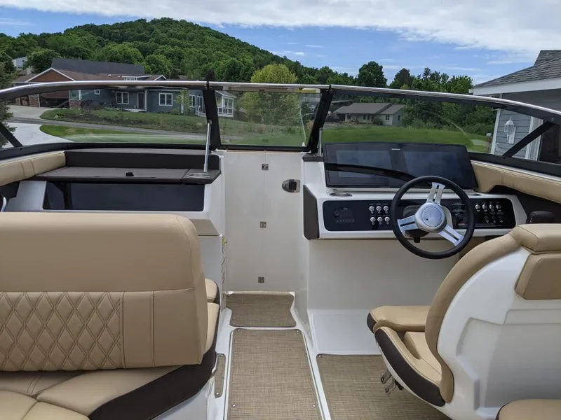 Slide: The Image of 2021 Sea Ray SLX 230 boat interior with beige seating and modern dashboard. - 4
