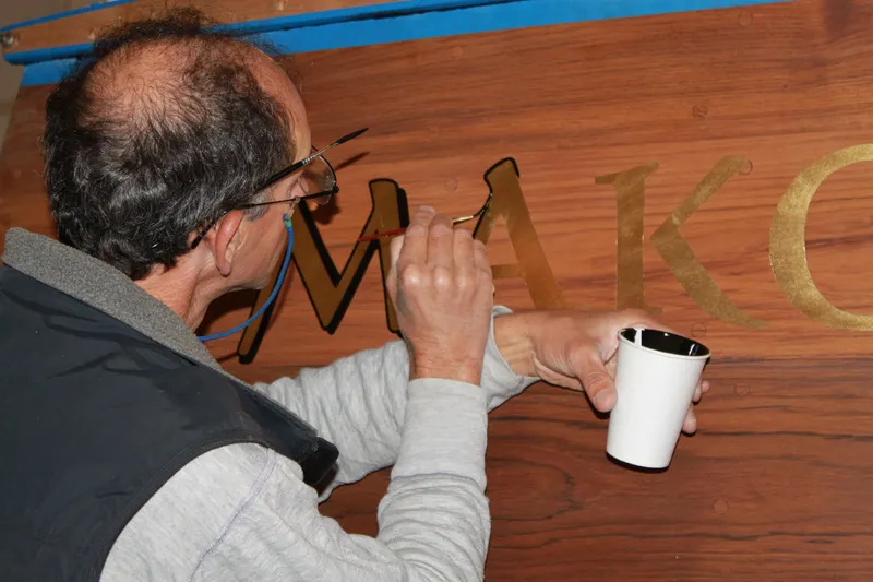 Slide: The Image of Man painting lettering on 1929 Stephens Brothers 34 Trunk Cabin Cruiser. - 17
