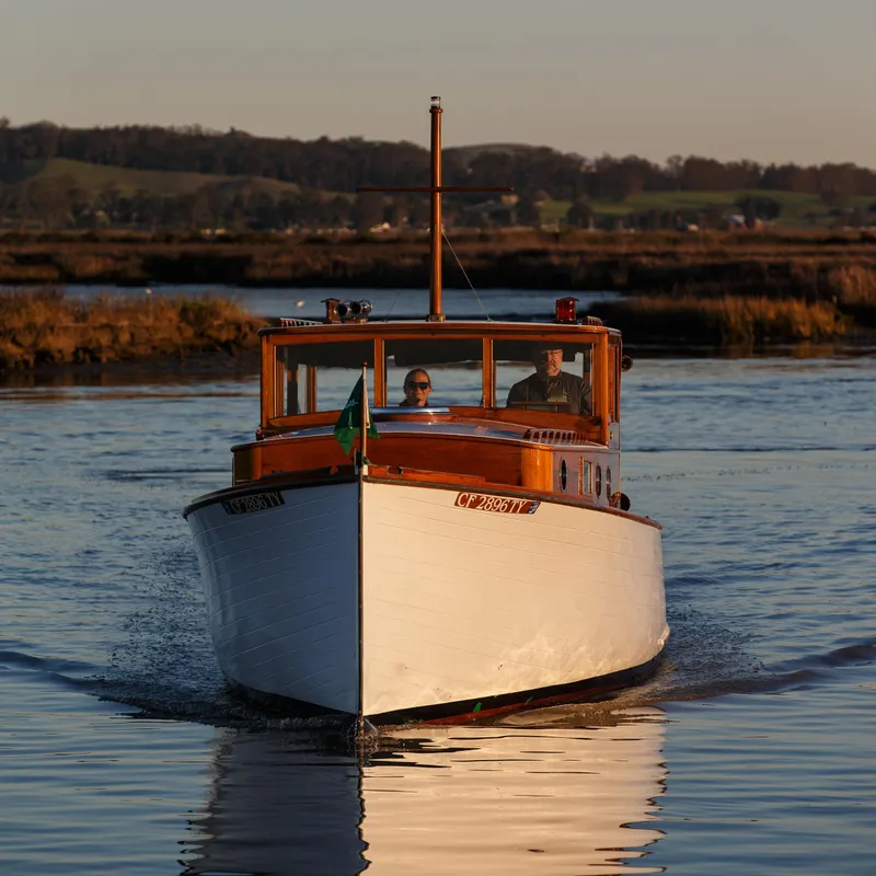 Slide: The Image of 1929 Stephens Brothers 34 Trunk Cabin Cruiser on serene water at sunset. - 2