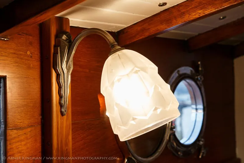 Slide: The Image of Vintage wall lamp inside 1929 Stephens Brothers 34 Trunk Cabin Cruiser, with porthole window. - 8