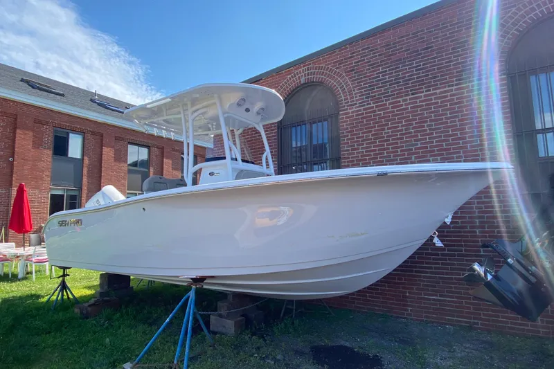 The Image of 2024 Sea Pro 222 Center Console boat displayed outdoors near a brick building. - 0