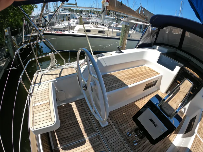 Slide: The Image of 2019 Hanse 388 yacht cockpit with wooden deck and steering wheel in marina. - 13