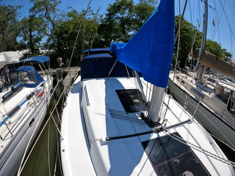 Slide: The Image of 2019 Hanse 388 sailboat docked, featuring a sleek white deck and blue sail cover. - 16