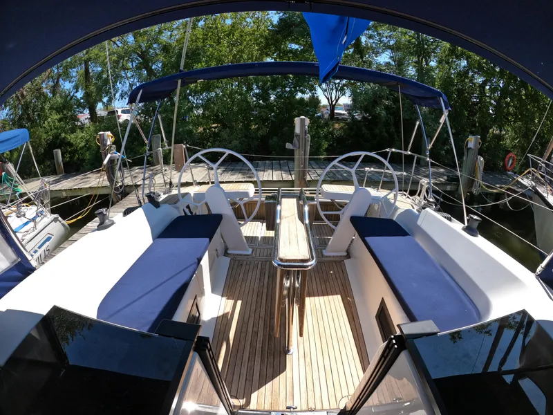 Slide: The Image of 2019 Hanse 388 yacht cockpit with dual steering wheels and blue seating. - 26