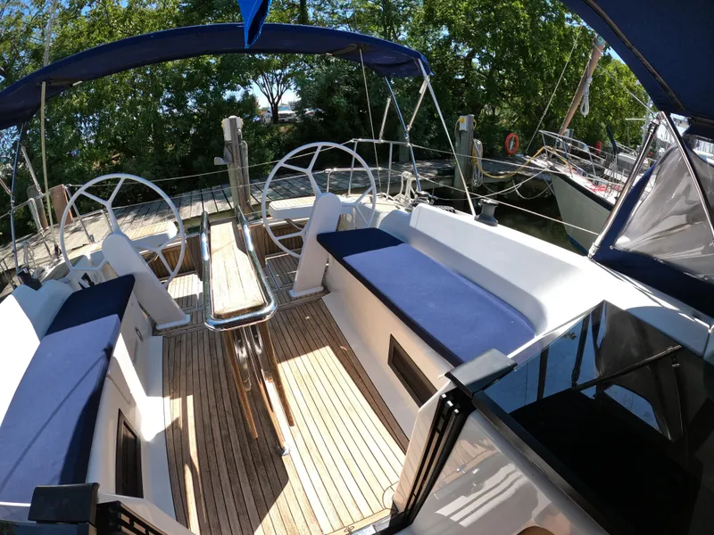 Slide: The Image of 2019 Hanse 388 yacht cockpit with dual steering wheels and blue seating. - 28