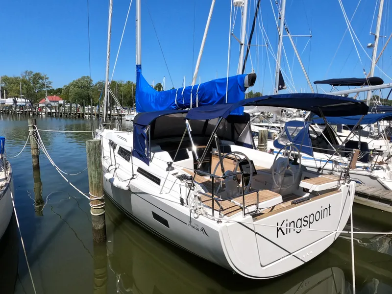 Slide: The Image of 2019 Hanse 388 sailboat docked, featuring blue sail cover and spacious deck. - 5