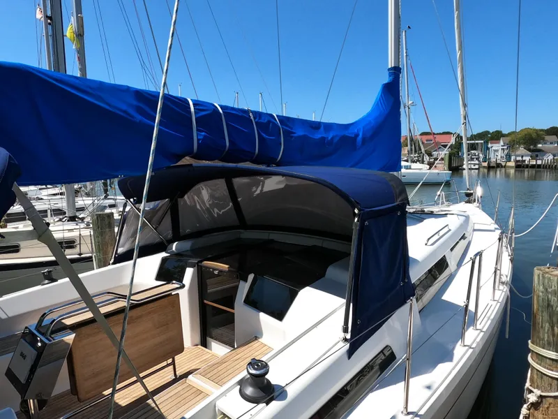Slide: The Image of 2019 Hanse 388 sailboat docked, featuring blue sail cover and cockpit canopy. - 7