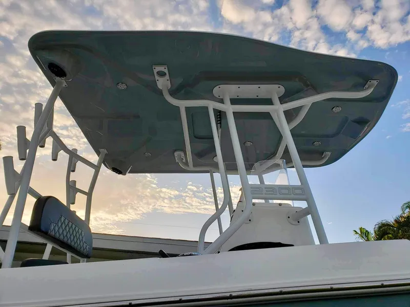Slide: The Image of 2022 Clearwater 2300 boat with T-top against a cloudy sky. - 11