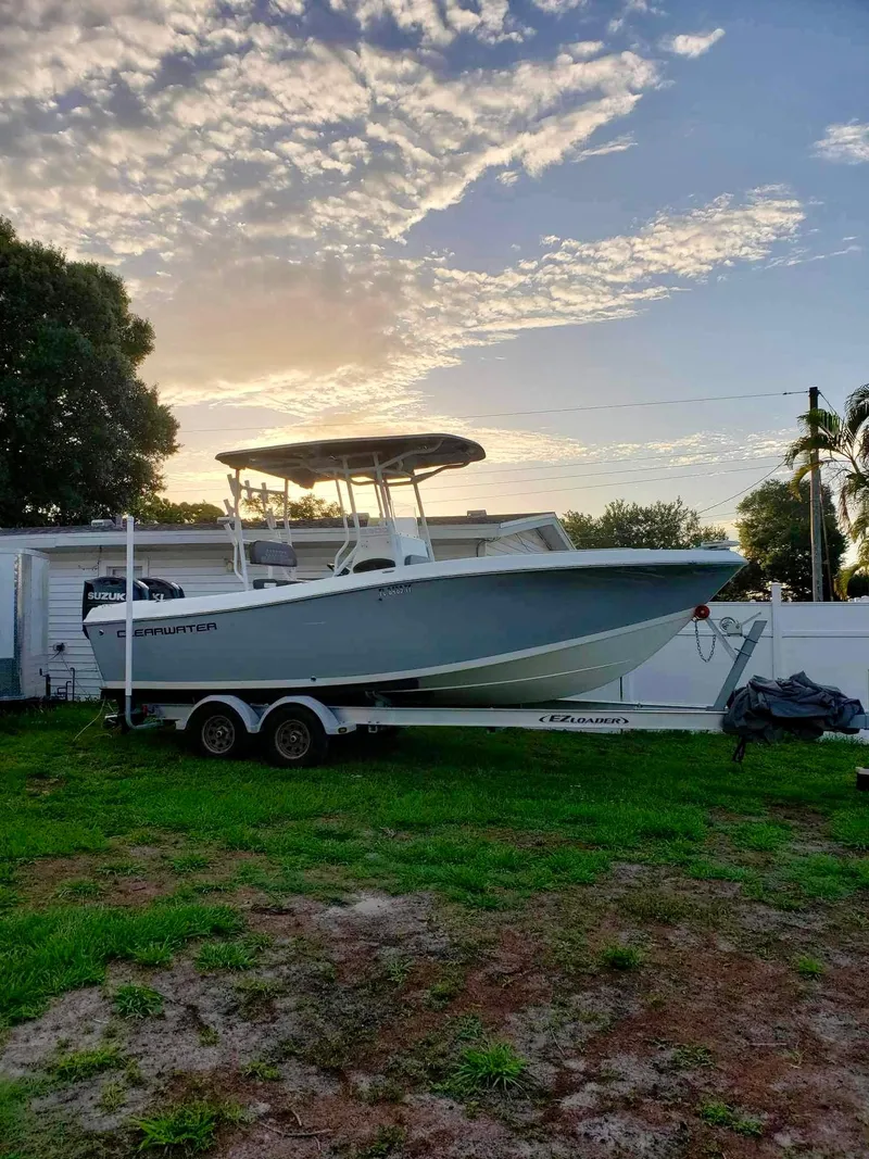Slide: The Image of 2022 Clearwater 2300 boat on trailer at sunset, parked on grass. - 8