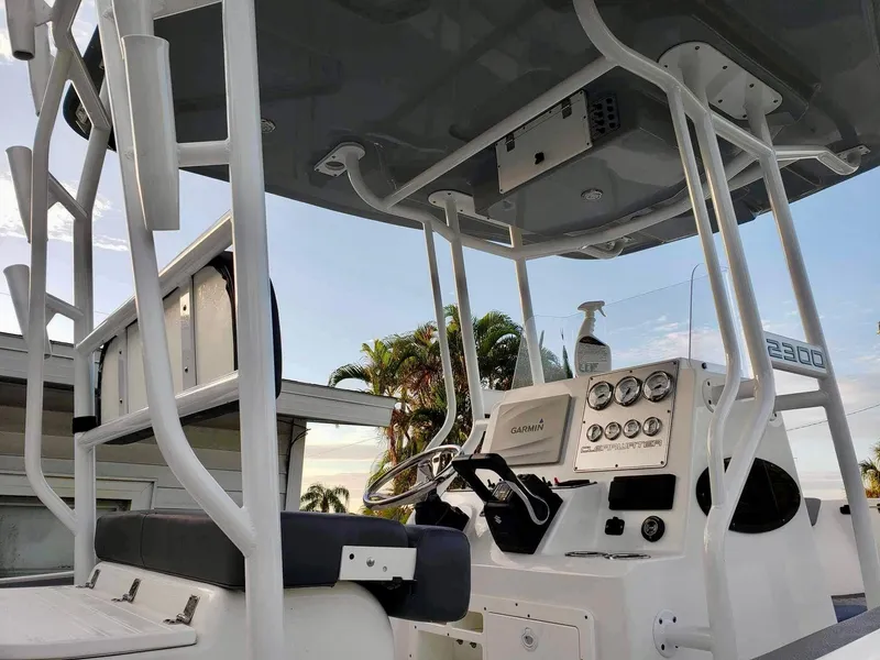 Slide: The Image of 2022 Clearwater 2300 boat console with steering wheel and gauges, under a canopy. - 10