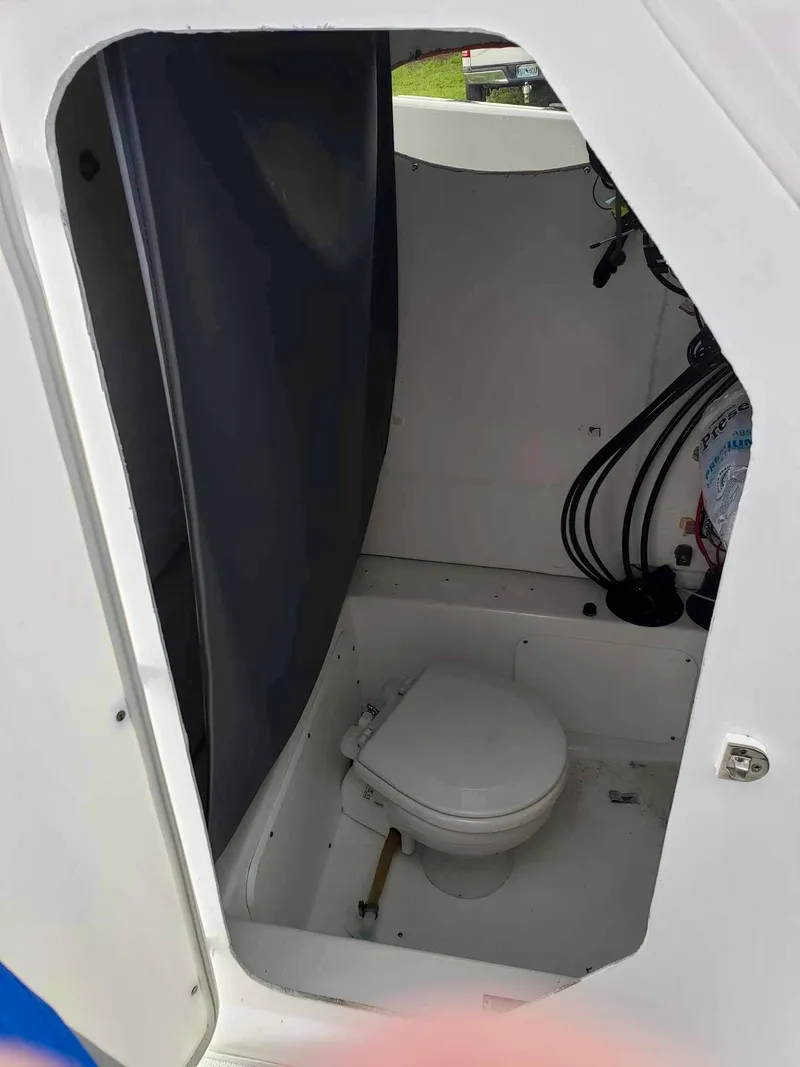 Slide: The Image of 2022 Clearwater 2300 boat interior with compact marine toilet and storage area. - 13