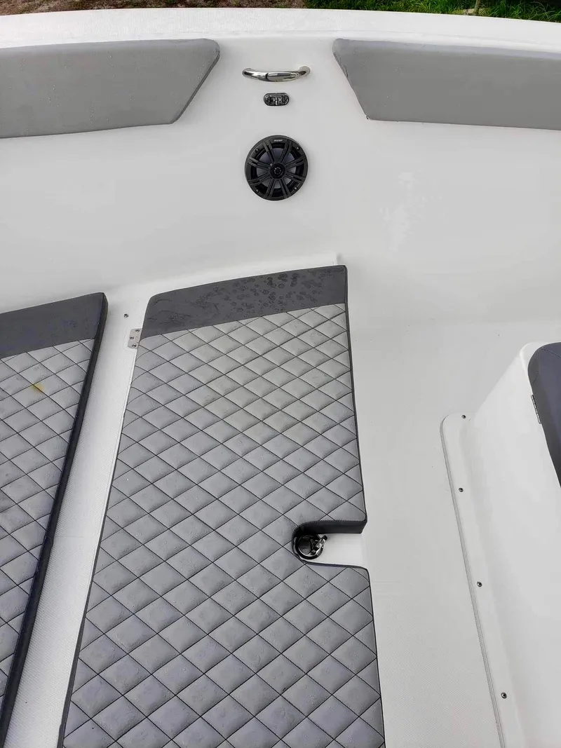 Slide: The Image of 2022 Clearwater 2300 boat interior with gray diamond-patterned flooring and speaker. - 14