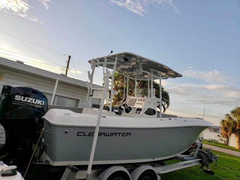 Slide: The Image of 2022 Clearwater 2300 boat on trailer with Suzuki outboard motor, parked near a house. - 4