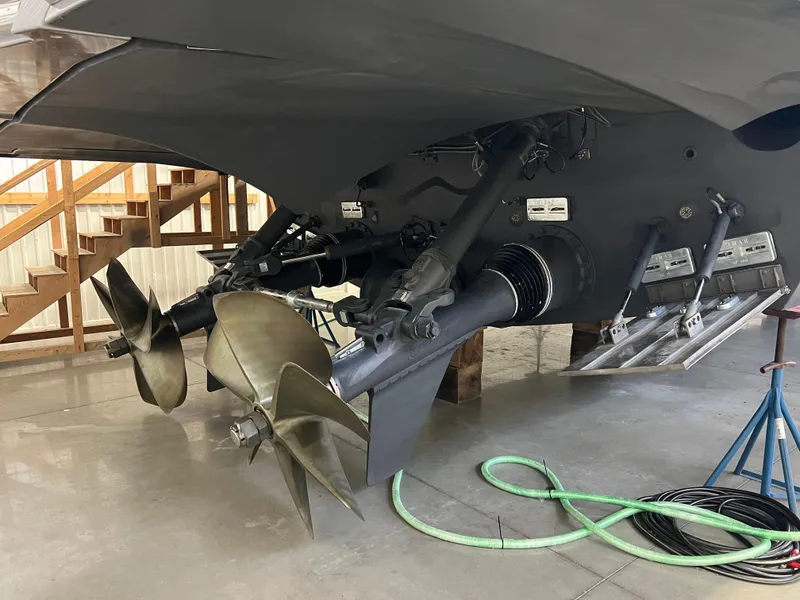 Slide: The Image of 2017 Pershing 92 Motor Yacht propellers and rudders in a maintenance facility. - 11
