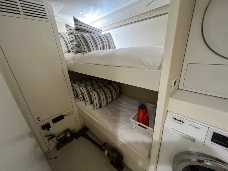 Slide: The Image of Bunk beds in 2017 Pershing 92 Motor Yacht cabin with striped pillows and laundry area. - 18