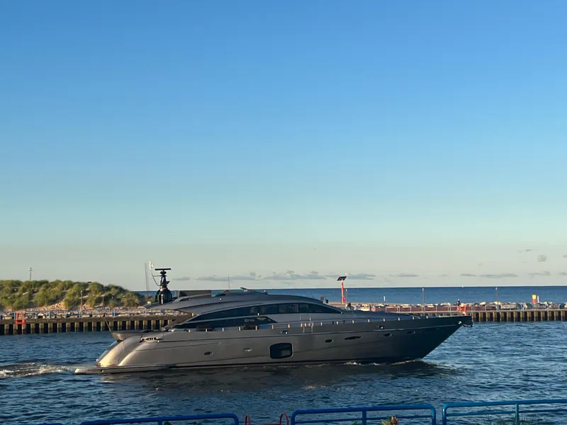 Slide: The Image of 2017 Pershing 92 Motor Yacht cruising near a coastal pier under a clear blue sky. - 2