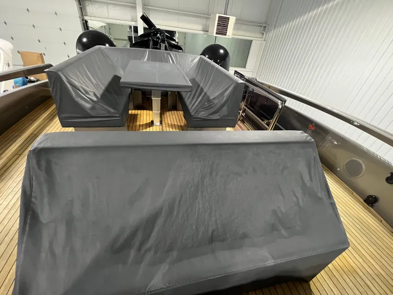 Slide: The Image of 2017 Pershing 92 Motor Yacht interior with covered seating and wooden deck. - 26