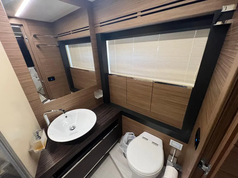 Slide: The Image of Luxurious bathroom in 2017 Pershing 92 Motor Yacht with modern fixtures and wood accents. - 39