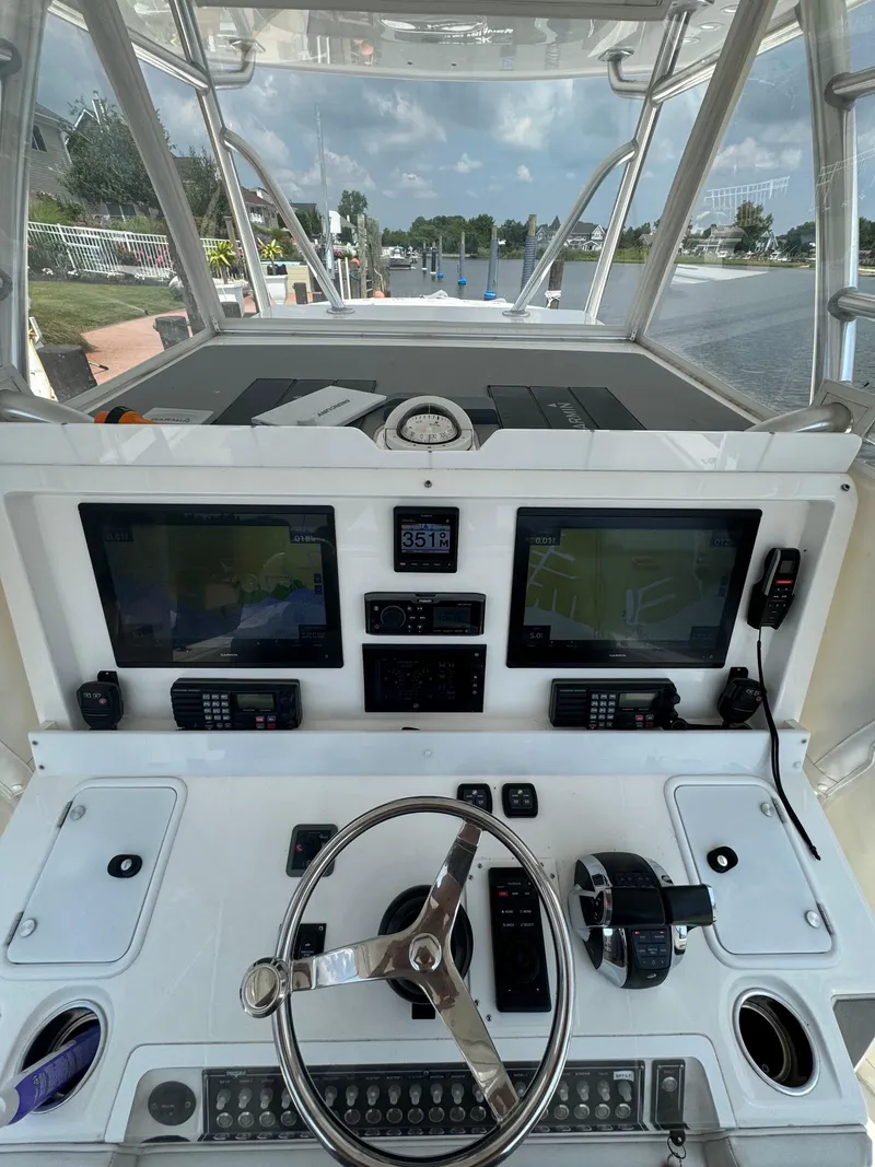 Slide: The Image of 2018 Invincible 43 Open Fisherman helm with dual displays and navigation controls. - 13