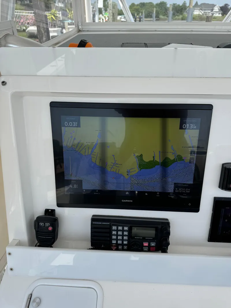 Slide: The Image of 2018 Invincible 43 Open Fisherman boat dashboard with navigation screen and radio. - 16